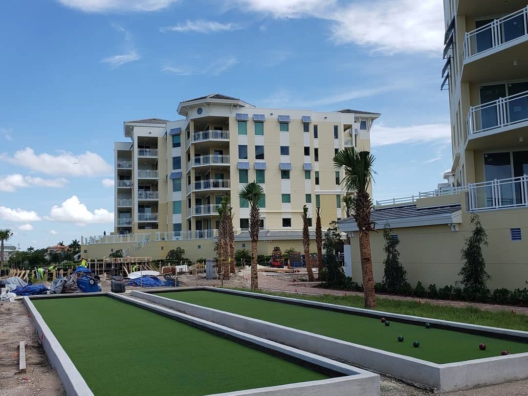 Twin bocce courts in front of a condominium tower